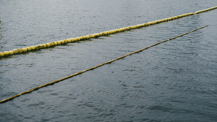 Yellow pool divider lines with floating buoys on the water surface