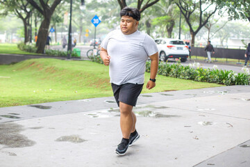 Young Fat Man In Sportwear Jogging on The Park