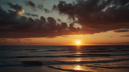 Obraz premium Dramatic sunset over the ocean with a stormy sky.