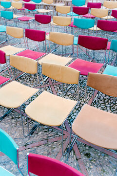Rows of Vibrant Chairs on Stone Pavement