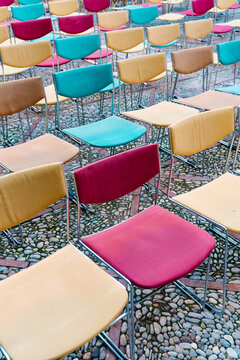 Vibrant Chairs Arranged on Cobblestone