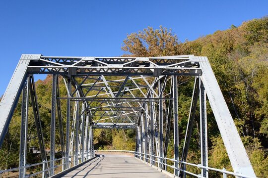 Steel bridge passing vehicles over the river to  continue down country lane