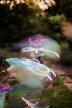 Kid with giant colorful soap bubbles