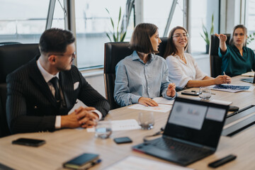 Multicultural group of business people collaborate in a modern office setting. They are actively...