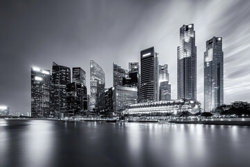 Fototapeta premium City skyline illuminated at night with modern skyscrapers along the waterfront
