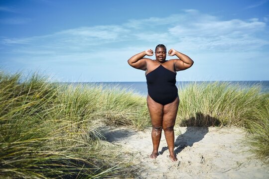 Confident woman enjoying a sunny beach day in a winner pose