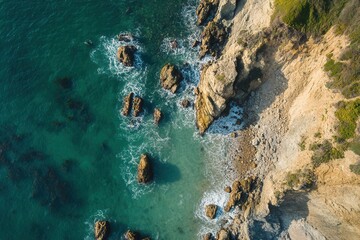 Aerial view of a rocky coastline with clear turquoise water.