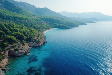Fototapeta premium Aerial view of a secluded beach with turquoise water and green hills.