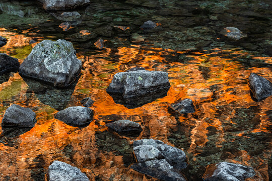Natural background with a mirror image in a mountain lake in autumn