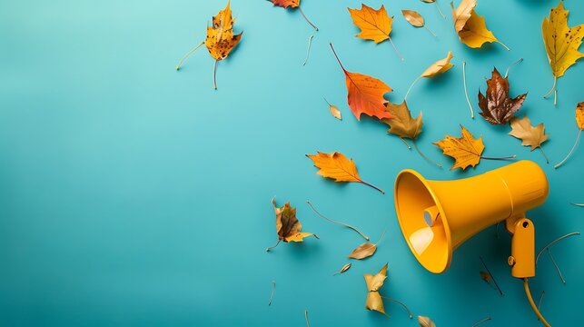 Yellow megaphone announcing autumn on turquoise background with copy space