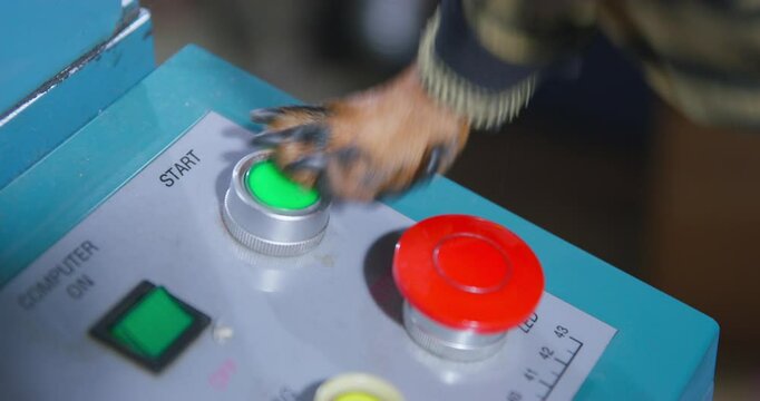 Close-up of a dog's paw pressing a red button on an industrial control panel, the intersection of technology and animals.