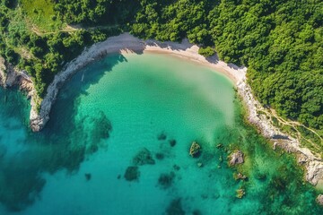 Obraz premium Aerial view of secluded cove with turquoise water, sandy beach, and lush green foliage.