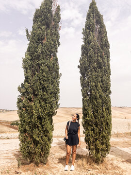 portrait of woman next to some cypresses in tuscany in italy