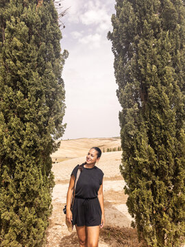 portrait of woman next to some cypresses in tuscany in italy
