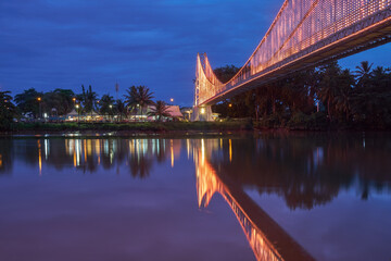 Satok Bridge is a suspension bridge in Kuching city, Sarawak during blue hour. Soft focus due to long exposure and low light condition.