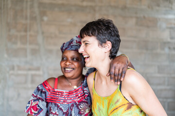 Senegalese woman and european volunteer laughing together in africa