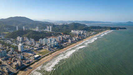 Panoramic photo of Praia Brava with the city of Itajaí in the background, one of Brazil's most important ports, on a sunny day.