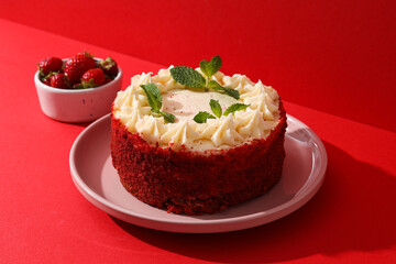 Red velvet cake on pink plate and berries on red background