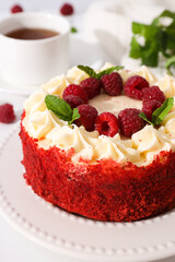 Red velvet cake, cup of tea, mint and berries on white background, close up