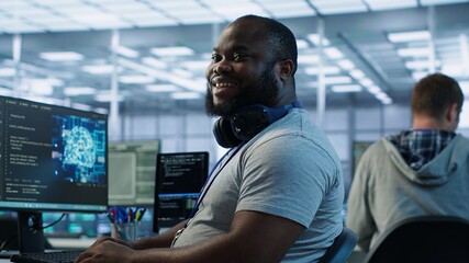 Happy engineer laughing at coworker joke while working in high tech AI facility. Jolly man amused...