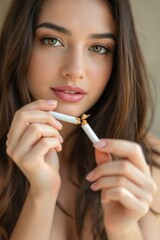 Obraz premium Young Woman Holding a Broken Cigarette with a Somber Expression