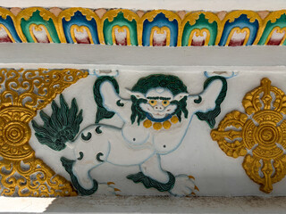 A gold and green dragon is depicted on a white background, Spiti Valley India.