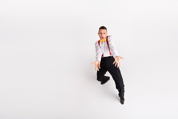 Energetic young man in vintage style strikes a dynamic dance pose