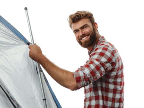 Man with a beard is smiling and holding a tent pole. He is wearing a red and white plaid shirt
