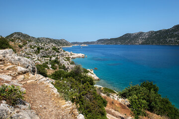 Fototapeta premium A beautiful Mediterranean coastal landscape with clear blue waters, rocky cliffs, and green hills, 