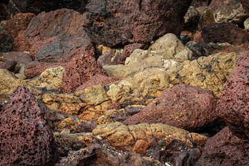Close-up of red laterite stone texture from Goa beaches, showcasing natural patterns and rugged surfaces. Perfect for design projects and creative use.