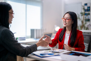 Two women shaking hands in a business setting