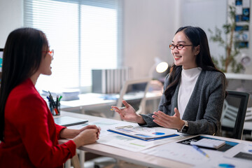 Two women are talking in a business setting