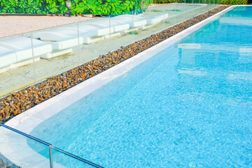 Empty swimming pool with sunbed and white umbrella in resort hotel for vacation leisure and white...