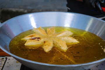 Bakso mekar is fried in a frying pan full of oil. Fried meatballs are street snacks served with sauce and mayonnaise.