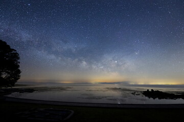 海面に星が映る能登半島の海岸と天の川