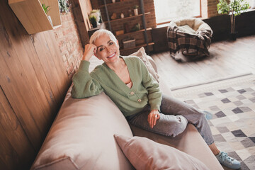 Obraz premium Charming elderly woman enjoying a cozy day at home in trendy sweater
