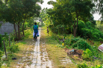 Teenage Girl Cycling to School on a Village Path in Rural India