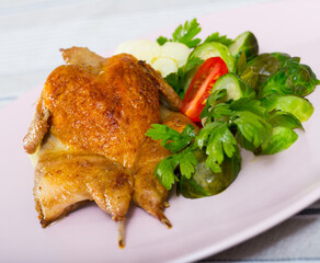 Baked spicy tobacco quail with vegetable garnish of steamed cauliflower, Brussels sprout, fresh tomato and parsley