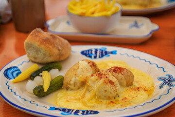 Melted raclette cheese with potatoes, pickles and bread, Swiss specialty at a cozy fondue chalet restaurant, Zurich Christmas Market, Switzerland