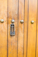 Close up of old Key in wooden door at home, Brown Wood Front Door with Ornate Brass Skeleton...