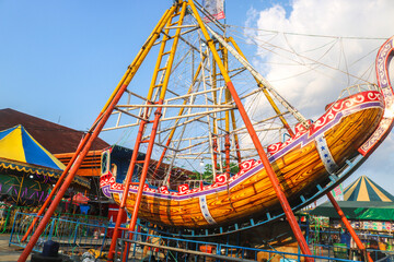 pirate ship or swinging boat in the amusement park in the afternoon. Rides the boat swing at the...