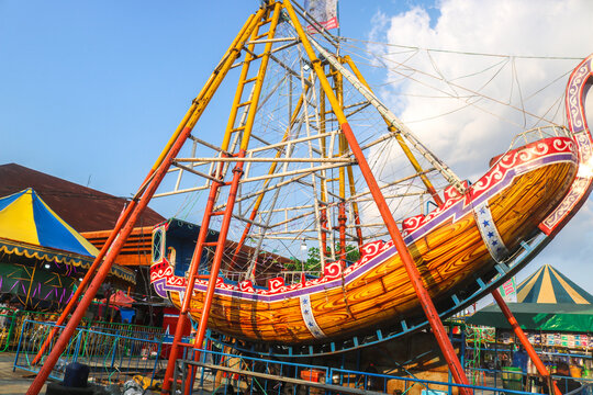 pirate ship or swinging boat in the amusement park in the afternoon. Rides the boat swing at the fun fair at night