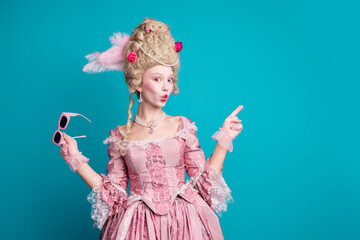 Fototapeta premium Photo of young woman direct finger empty space wear renaissance queen costume isolated on teal color background