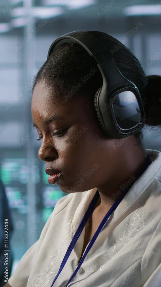 Poster vertical video portrait of smiling engineer hearing podcasts to make time pass faster while working 