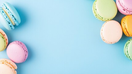 Colorful macarons on a pastel blue background, a flat lay top view. The background features colorful sweet cookies.