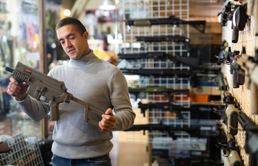 Man chooses semi-automatic pneumatic assault rifle at a gun store
