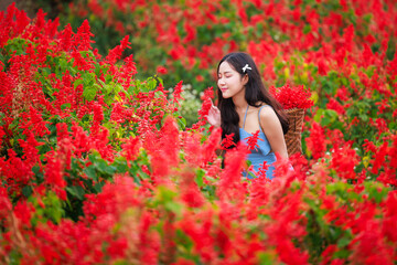 Naklejka premium young woman very happy at the red flower garden.