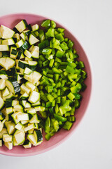 chopped up green bell peppers and zucchini on wooden cutting board, natural healthy ingredients