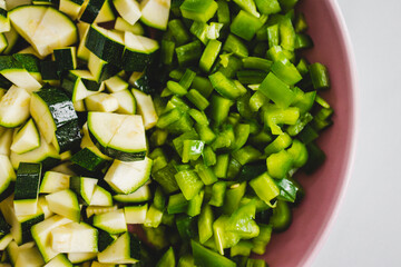 chopped up green bell peppers and zucchini on wooden cutting board, natural healthy ingredients