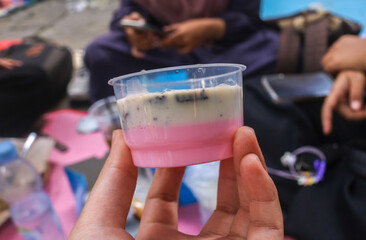 vanilla and strawberry pudding with biscuit crumbs in mini cup isolated on pink background